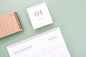 White and brown calendars on green background top view close-up, planning concept.