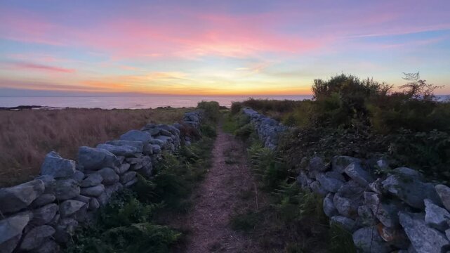 Path with Two Stone Fences Leading to Ocean During Sunset