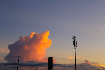 A silhouette of telco tower with beautiful sunset and cloud on the background