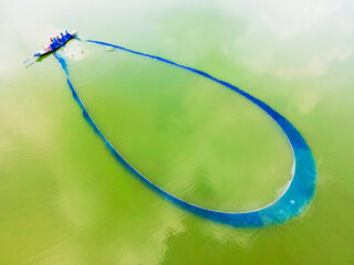 Fishermen catch all kinds of fish in colourful large nets from submerged open ground ghat in Bill area of ​​Shahjadpur upazila of Sirajganj district, Bangladesh.