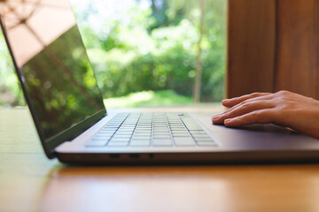 Closeup image of a woman working and touching on laptop computer touchpad