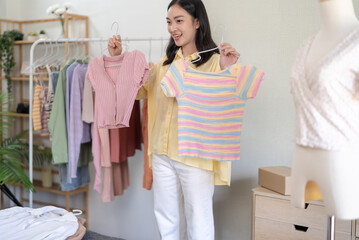 Asian Woman dressmaker working in fashion studio design and shipping an online order with woman sending package online consulting at clothing shop