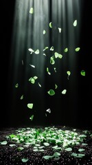 Fototapeta premium A serene display of green leaves floating in a beam of light against a dark background.