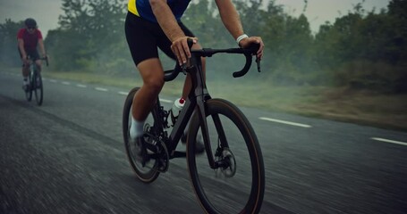 One Athlete Rides at the Front, Setting the Pace for Two Cyclists Trailing Behind. Professional Team Power Through the Long Road, Training for Peak Performance. Focus on Wheels and Bicycle