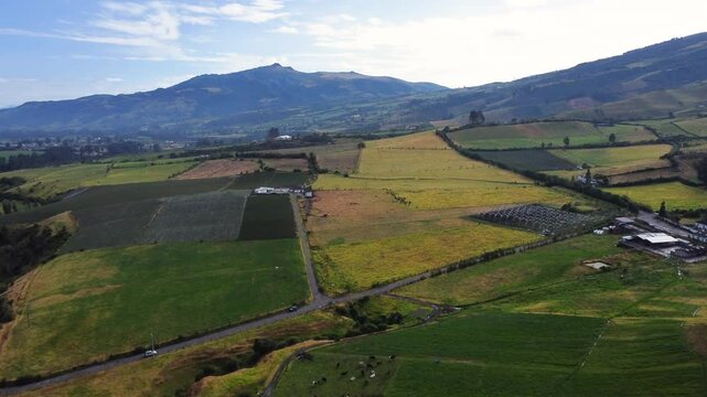 Stunning aerial view showcasing Pasochoa Volcano, green fields, winding roads, and distant rolling hills under a clear blue sky in romerillo sector, Machachi parish, Mejia canton, Pichincha, Ecuador