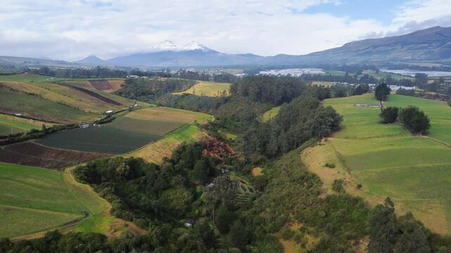 Reveal breathtaking aerial landscape featuring expansive green valleys inromerillo sector, Machachi parish, Mejia canton, Pichincha, Ecuador, showcasing Los illinizas volcano