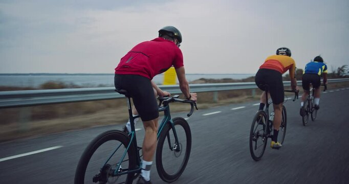 Dynamic Rolling Shot with Cycling Team Powering Through a Country Road on a Windy Day. Professional Riders in Uniform Demonstrate Exceptional Teamwork, Speed and Performance. View From the Back