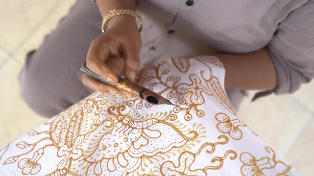 The technique of making hand-drawn batik using a canting tool. This craftsman is making batik typical of Giriloyo Bantul Yogyakarta.