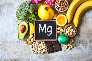 Magnesium-rich foods including avocado, bananas, nuts, dark chocolate, and vegetables arranged...