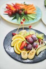 A plate with various fruits on the festive table
