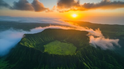 A breathtaking aerial view of a volcanic crater surrounded by lush green vegetation, bathed in the golden light of a dramatic sunrise.