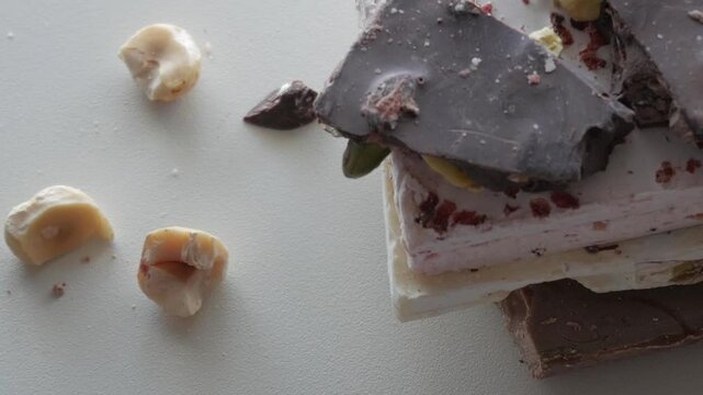 A collection of artisan chocolates with nut toppings displayed on a white background, capturing an elegant and delicious theme.