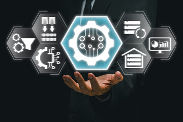 A businessman holding a digital gear icon symbolizing the ETL process in data management,...