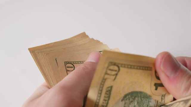 hands and a ten-dollar stack on a white background