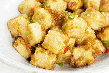 Stirred Tofu: Vegetarian Asian Style.This vibrant dish features crispy stir-fried tofu, perfectly marinated for flavor and texture. The tofu is coated in soy sauce and sesame oil, a rich umami taste.
