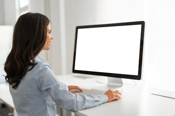 Young woman working on her computer with mockup screen