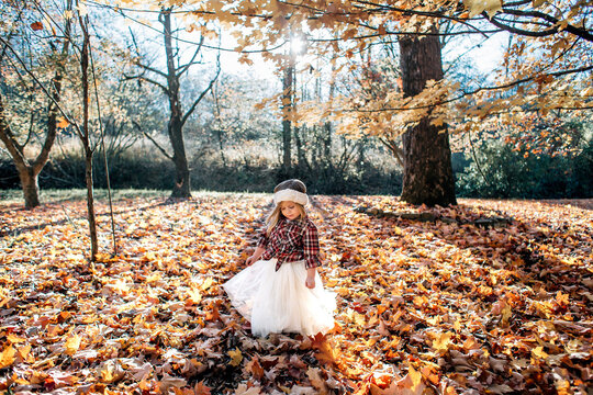 Young Girl in dress dancing in an Autumn Leaves