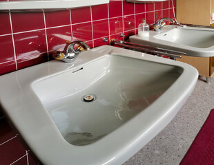 Fototapeta premium Zwei Waschbecken an roten Fliesen