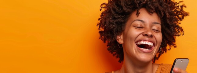 Woman with curly hair laughing while holding her phone against an orange background, banner ad. Web design template with copy space. african american woman smartphone isolated on orange background