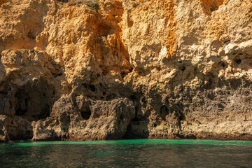 Textured natural background of rock and ocean. Rocks in the Algarve region, Portugal 