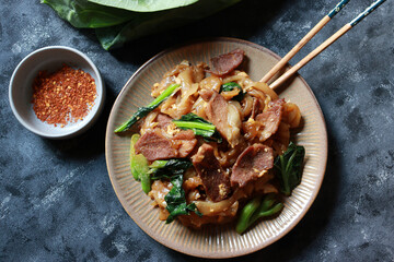 Stir fried rice noodle with soy sauce, pork meat, egg and Chinese Broccoli. Thai street food Pad See Ew