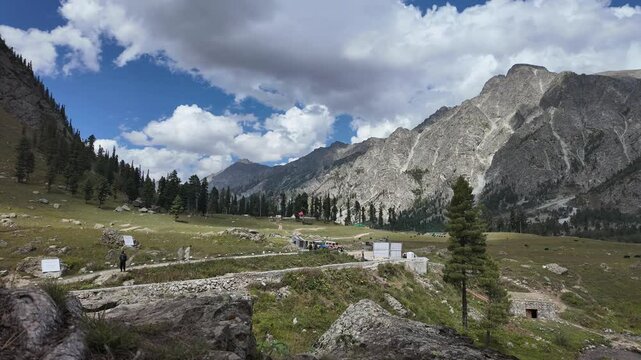  Time Lapse Serene Mountain Lake Landscape with Dramatic Clouds,Sunshine,Dark Skies, Featuring a Pictures que Valley,Green Meadows, and Traditional Huts, with Vehicles and People Enjoying Nature,4k.