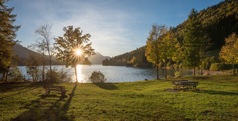 picnic area lake Walchensee at sunset, bright sun with rays. autumnal landscape bavaria