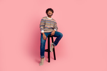 Full body photo of nice young man sit stool empty space isolated on pink color background