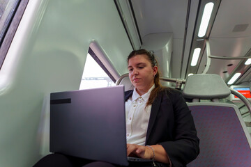 Young Businesswoman Working on Laptop While Traveling by Train