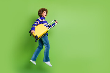 Photo of cheerful glad woman wear blue striped trendy clothes hold valise baggage empty space isolated on green color background