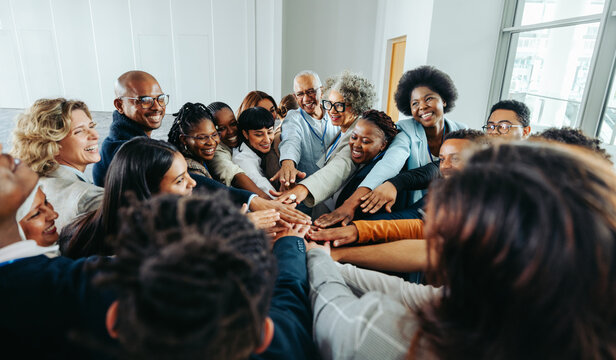 Diverse team of smiling people united in a group huddle showcasing unity and teamwork