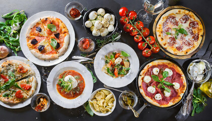 A beautifully arranged Italian feast featuring various pizzas, fresh salads, and gourmet ingredients on a rustic table setting