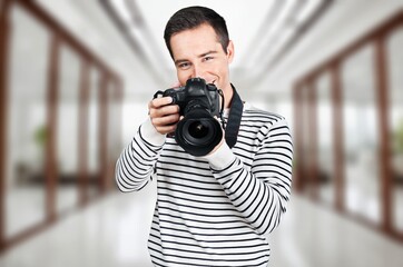 Focused Young Videographer with Professional Camera In Studio