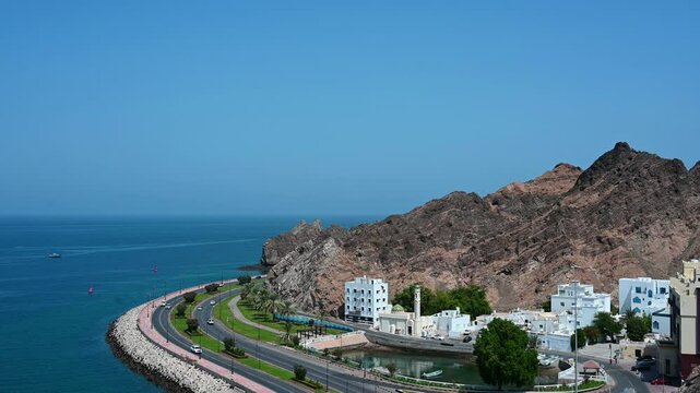 Panoramic view of old historical part Muscat Muttrah with embankment, mountains and sea in Oman