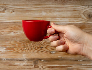 Hand Holds Cup, Empty Red Cup in Hands, Coffee Mug, Teacup Mockup, Cup in Arms on Wooden Table