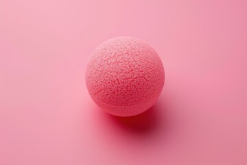 A textured pink sphere resting on a pastel pink surface