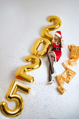 Miss Santa Claus lies on a white background surrounded by gifts and the inscription 2025, top view