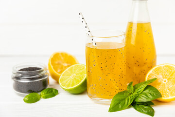 Diet detox cocktail with basil and chia seeds in a glass jar and a glass on a textured background....