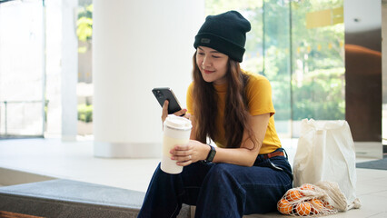 Go green Gen z asia people young woman sitting on floor relax smile using mobile phone app typing...