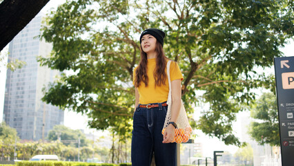 Go green Gen Z woman asia young people carrying eco tote mesh bag reuse walk in city nature tree public park save the earth planet world care. Reduce issues asian hope net zero waste the way forward.