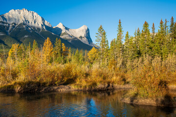 Beautiful scenery of the Canadian Rockies at dawn in autumn. Mountain, forest in yellow and green...
