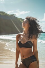 Obraz premium young fit woman with black curly hair on the beach