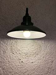 Black hanging lamp with white light against white wall. Close-up of black lamps on ceiling. Modern...