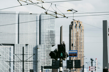 This urban scene features a pedestrian crossing and traffic lights amid towering office buildings, signifying city life and human interaction with architecture.
