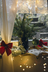 Cozy Christmas still life on the window with fir branches, Christmas cookies and lights.