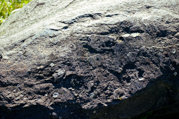 Detail of stone texture in wild nature. Stone, surface, texture. Stone irradiated by the sun, strong shadow.