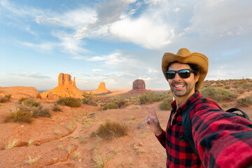 handsome tourist takes selfie photo in Monument Valley, meaning valley of the rocks, which is a...