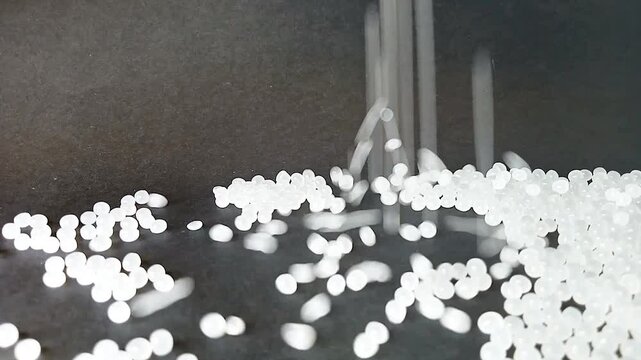 white masterbatch granules, cold cutting type, lined up in a circle, isolated on a black background, for product video catalog design of industrial plastic company profile