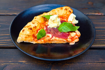 Italian pizza with one slice on wooden table. Italian Pizza Manzo.