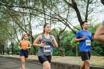 fit asian woman running on marathon event wearing sportswear